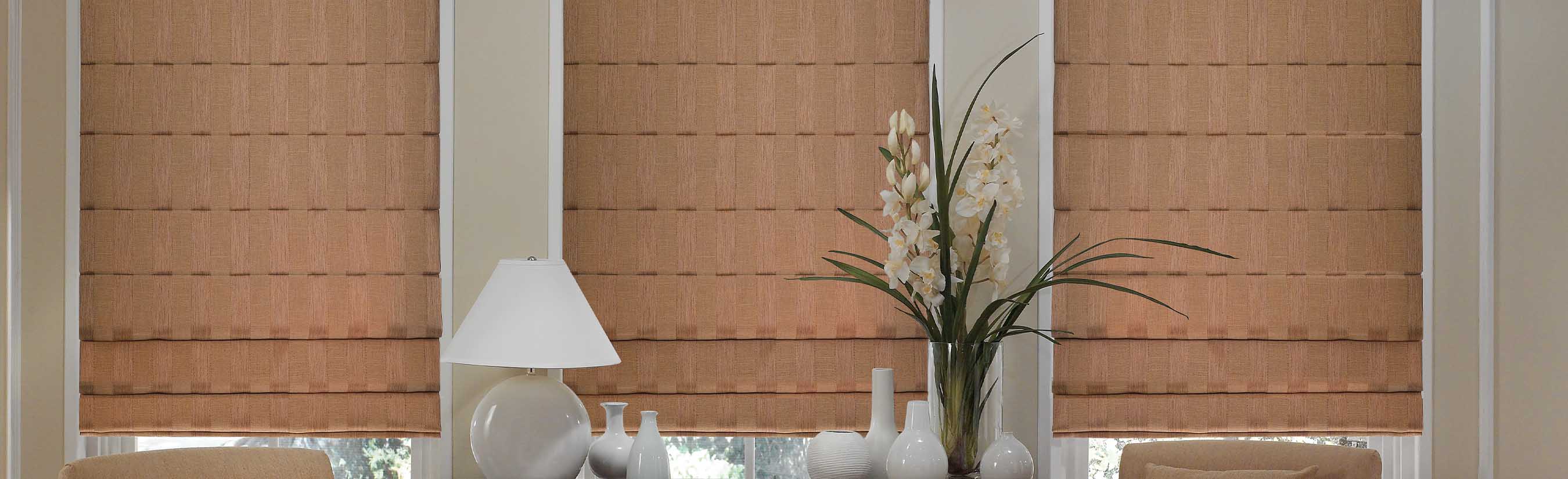 Tan Roman shades in a bedroom.