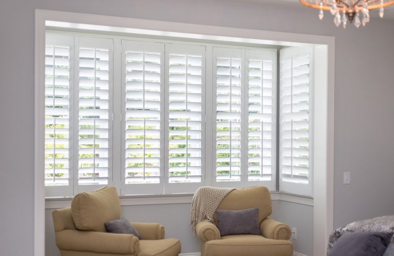 North-South windows may have energy efficiency issues instead of sun glare problems. White plantation shutters in sitting area