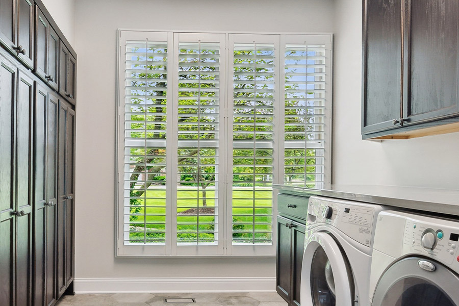 Find the perfect level of natural light for your Orlando laundry room with interior shutters. White Polywood shutters letting light through a laundry room window