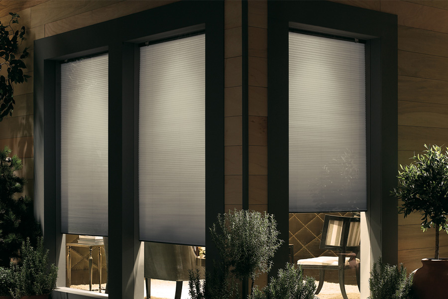 Cellular shades are modern and stylish window treatments for your home in Orlando. Dark gray cellular shades displayed from the exterior of a home.